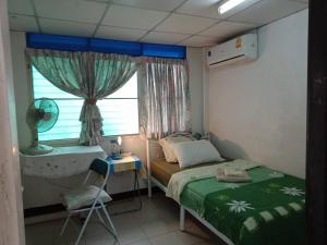 曼谷年轻美丽旅馆的一间小卧室,配有床和窗户