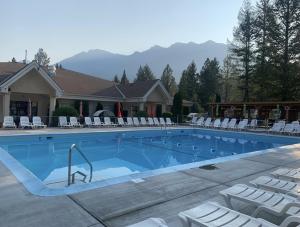镭温泉RidgeView Resort的一个带白色椅子和房子的大型游泳池
