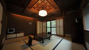 京都柚子屋旅馆的客厅配有桌子和电视。
