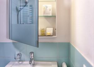 乌斯特Hotel Residence Loren - contact & contactless check-in的一间带水槽和镜子的浴室
