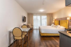 乌斯特Hotel Residence Loren - contact & contactless check-in的酒店客房带一张床、一张桌子和椅子