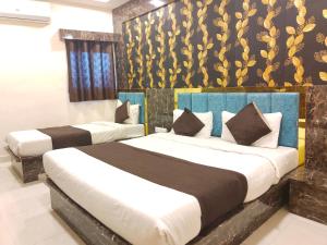 加姆布Hotel Bhavya Residency的一间卧室设有两张床和一堵金色墙