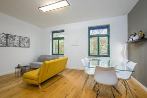 莱比锡Arbio I Modern Apart near Leipzig Stötteritz的客厅配有黄色椅子和玻璃桌