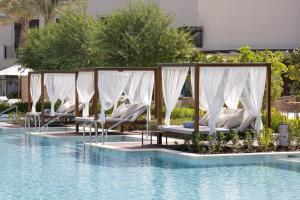 麦纳麦Jumeirah Gulf of Bahrain Resort and Spa的游泳池旁的一排躺椅