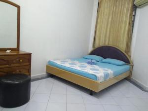 Kampong BinjaiRumah Tamu AZ Pasir Tumboh的一间卧室配有一张床、梳妆台和镜子