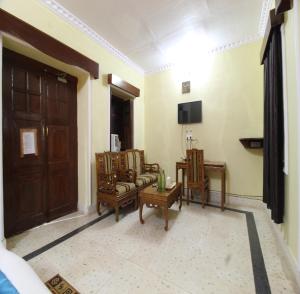 塔拉Maharaja Kothi Resort, Bandhavgarh的客厅配有椅子、电视和门