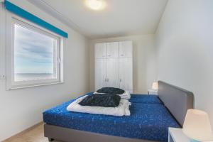 布雷斯肯斯Hello Zeeland - Appartement Port Scaldis 03-071的一间卧室配有一张带蓝色床单的床和一扇窗户。