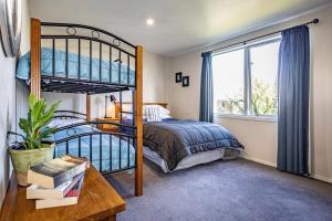 国家公园Ruapehu Retreat的一间卧室配有双层床和书桌