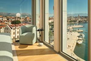 斯普利特Hotel Ambasador的客房设有带椅子的窗户,享有美景。