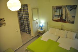 佩弗奇ARTEMIS ROOMS的一间卧室配有绿色的床和镜子
