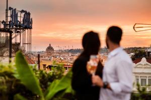罗马Hotel 87 eighty-seven - Maison d'Art Collection的两个人站在屋顶上,望着城市