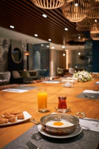 伊斯坦布尔伊斯坦布尔里士满酒店的一张桌子,上面放着一盘鸡蛋和一杯橙汁