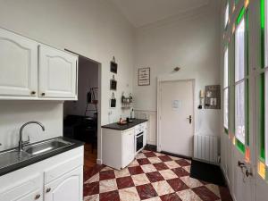 特鲁瓦Bed & Bulles的厨房配有白色橱柜和 ⁇ 格地板