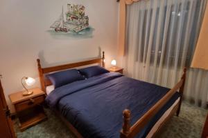 洛克维APARTMENT GORDANA A4+2 FOR 6 PAX NATURE PARK的一间卧室配有一张带蓝色床单的床和一扇窗户。