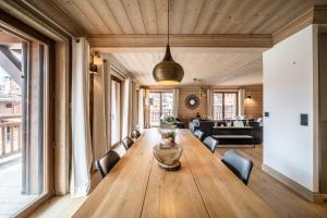 谷雪维尔Apartment Cervino Monriond Courchevel - by EMERALD STAY的配有椅子的房间里一张大木桌