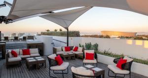 开普敦ANEW Hotel Green Point Cape Town的庭院配有桌椅和遮阳伞。
