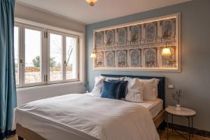 威尼斯卡玛丽亚阿黛尔旅馆的一间卧室配有一张带蓝白色枕头的大床