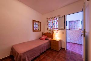 Las Marciegas3 bedrooms house at Los Caserones 50 m away from the beach with enclosed garden and wifi的一间卧室设有一张床和一个滑动玻璃门