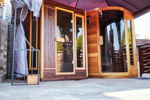 Chilia VecheCasa Chilia Resort&Spa的一座木房子,在庭院设有玻璃门