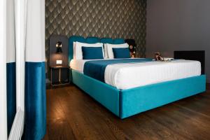 罗马Hotel 87 eighty-seven - Maison d'Art Collection的一间卧室配有蓝色的床和蓝色和白色的枕头