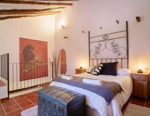 BlancaCasa rural con jacuzzi y chimenea en paraje único - La Casa del Pino的卧室配有一张床,墙上挂有绘画作品