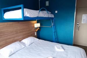 滨海贝尔克The Originals Access, Hôtel les Iris, Berck-sur-Mer的一间蓝色客房的卧室,配有两张双层床