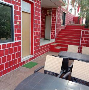马泰兰altafs motel的一座带桌椅的庭院和一座砖砌建筑