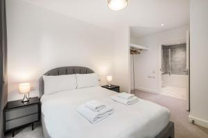 伦敦Stayo Apartments Barking Wharf的卧室配有白色床和毛巾