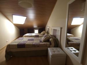 桑托多明戈德锡洛斯Casa Rural El Cipres的阁楼卧室配有两张床和镜子