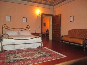 格罗佩洛凯罗利坎托尼旅馆的一间卧室配有床、沙发和地毯。