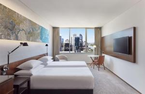 布里斯班Hyatt Regency Brisbane的一间酒店客房,设有两张床和电视