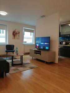 维也纳Apartment Tesla的客厅配有平面电视和桌子。