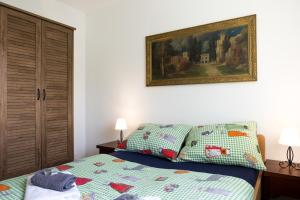 AljmašRiver Side的卧室配有一张床,墙上挂有绘画作品