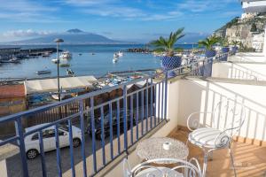 维克艾库塞乐安克勒酒店的阳台配有桌椅,享有海港的景致。