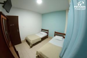 戈亚尼亚Pousada do Gui-Gui Aeroporto的小房间设有两张床和窗户