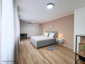 艾森斯塔特St. Antoni Suite 5的一间卧室配有一张床,铺有木地板