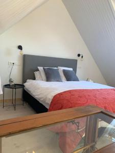 LasneLovely 1-bedroom appartement Le Joyau with indoor pool and sauna的一间卧室配有一张红色棉被的床