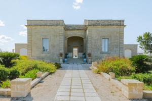 韦尔诺莱Relais Masseria Le Cesine - CDSHotels的石头建筑,有通往门的通道