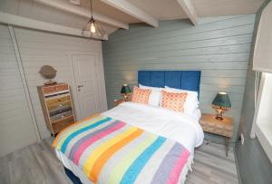 马罗斯普林堡大厅酒店的一间卧室配有一张带彩色条纹毯子的床