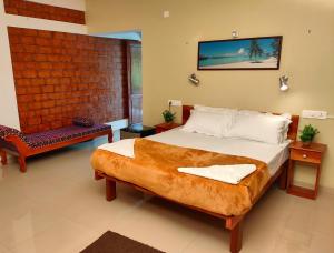 特里凡得琅Dr Nisha's Vedic Remedies的一间卧室配有一张大床和一把椅子