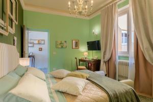 卢卡Villa De Maestri的一间卧室设有绿色的墙壁和一张带枕头的床
