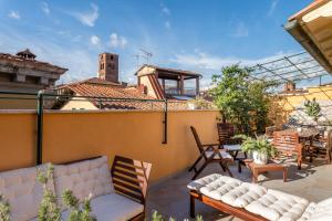 卢卡Villa De Maestri的屋顶上带沙发和桌子的庭院