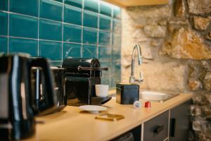 雅典Cohort Koukaki的厨房柜台配有咖啡壶和水槽