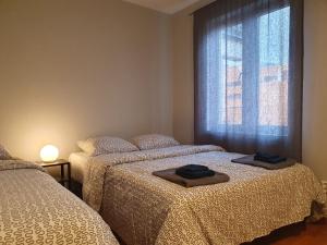 奥斯陆Bedroom in apartment 12 minutes to Oslo City by train的宿舍间的两张床,配有带毛巾的窗户