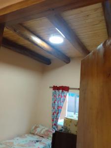 卢汉德库约Casa Kloeh的一间卧室设有一张床和木制天花板