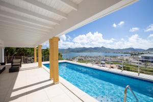 马霍礁Reflection Y 5 Star Villa的从带游泳池的房屋阳台欣赏风景