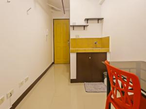 马尼拉OYO 882 City Stay Inns Makati City Hall的厨房配有橙色椅子和黄色门