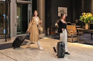 伦敦InterContinental London - The O2的两名妇女带着行李走过大楼