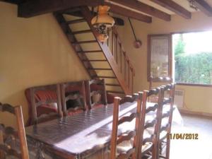 厄热涅莱班Les Chênes 2 - cadre verdoyant的一间带木桌和椅子的用餐室