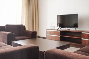 米里Bay Resort Condominium 3-bedrooms with Swimming Pool near the Seaside的客厅配有2把椅子和平面电视
